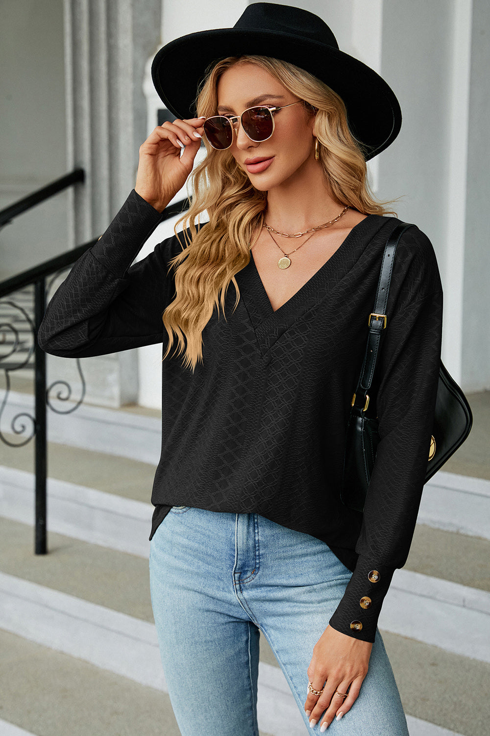 Black V-neck blouse with diamond texture and button cuff detail