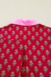 Red cotton mini dress with pink floral print, pink collar, and puff sleeves.