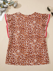 Smocked ruffled print blouse with animal pattern and red trim on sleeves.