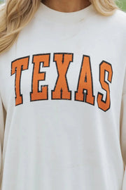 White crewneck sweatshirt with distressed orange "TEXAS" graphic