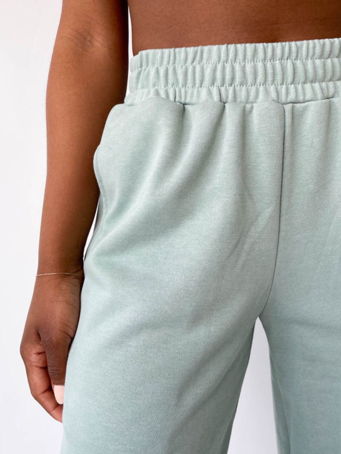 Light green wide-leg lounge pants with elastic waistband and pockets.