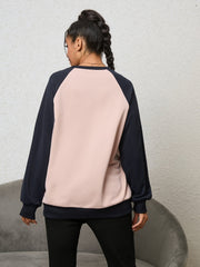 Blush pink and navy raglan sweatshirt with crew neck and cuffed sleeves.
