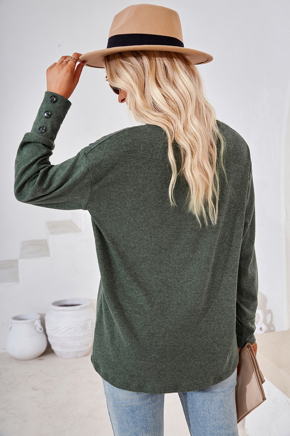 Button-cuff slouch v-neck top in dark green with button details on the sleeve cuff.