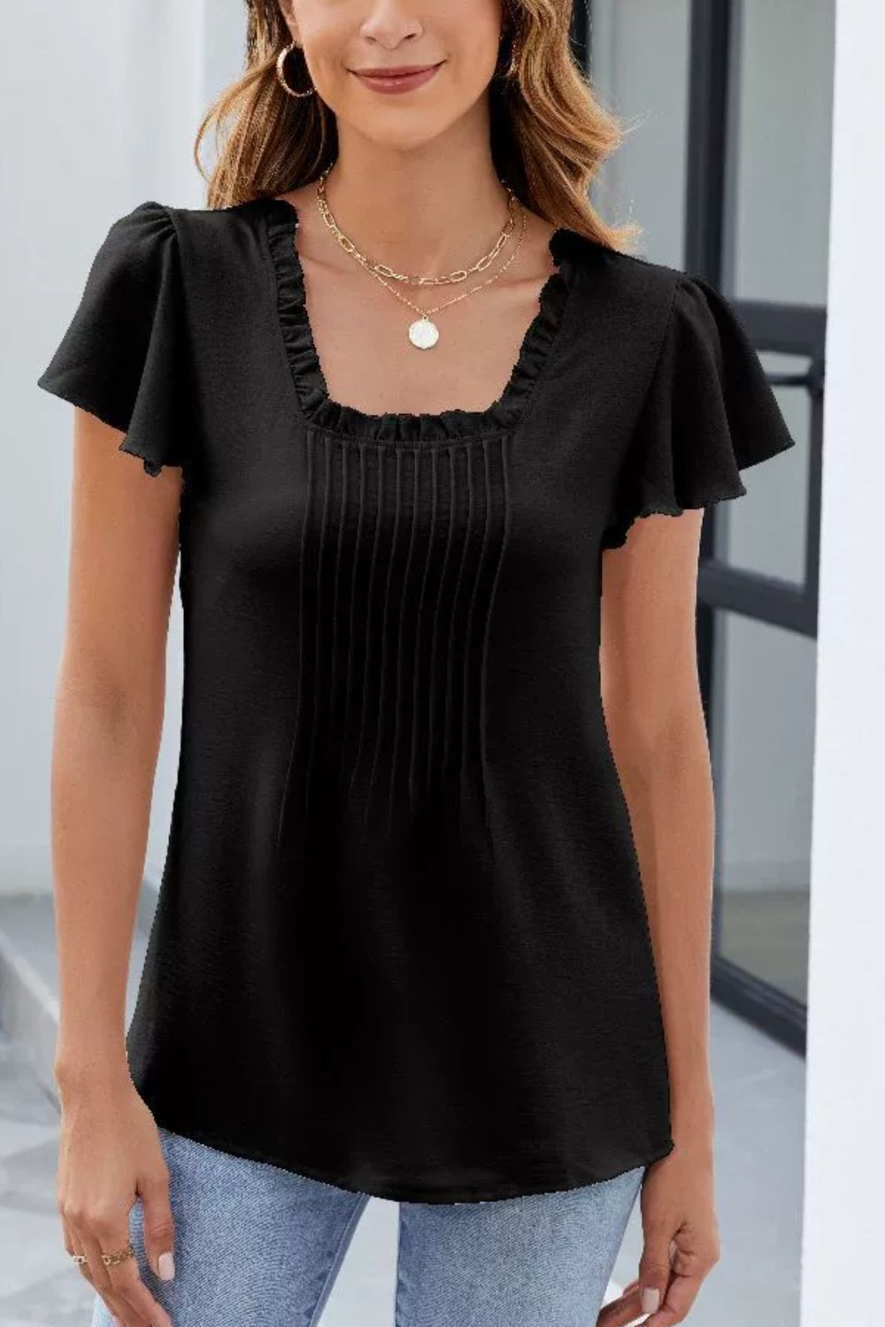 Black ruffled square neck blouse with short flutter sleeves and front pleats.