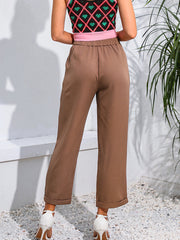 Taupe tailored crop trousers with button detail and cuffed hems.