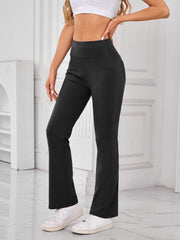 Black flared activewear pants with pocket detail and a high waist.