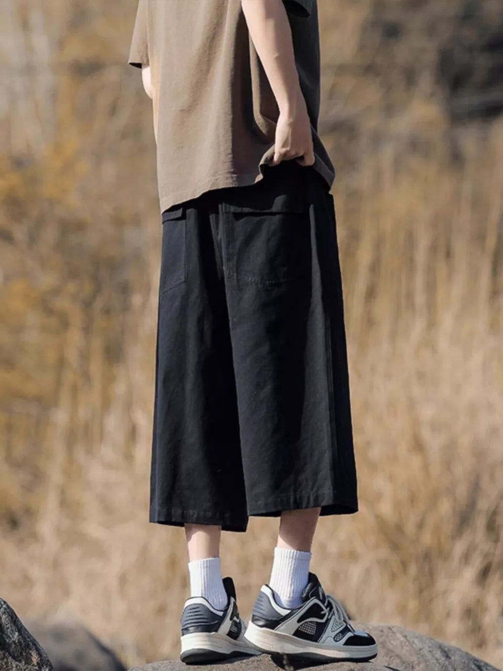 Black relaxed fit cropped sweatpants with drawstring and pockets.