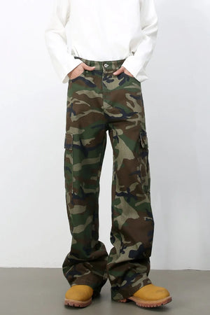 Wide-leg camo cargo pants in green camouflage pattern, 100% cotton, with multiple pockets.