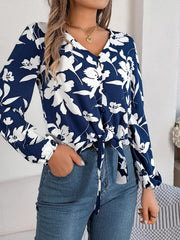 Navy floral knot-front blouse with ruffled cuffs and button detail.