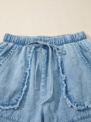 Light wash denim shorts with elastic drawstring waist and frayed pocket details.