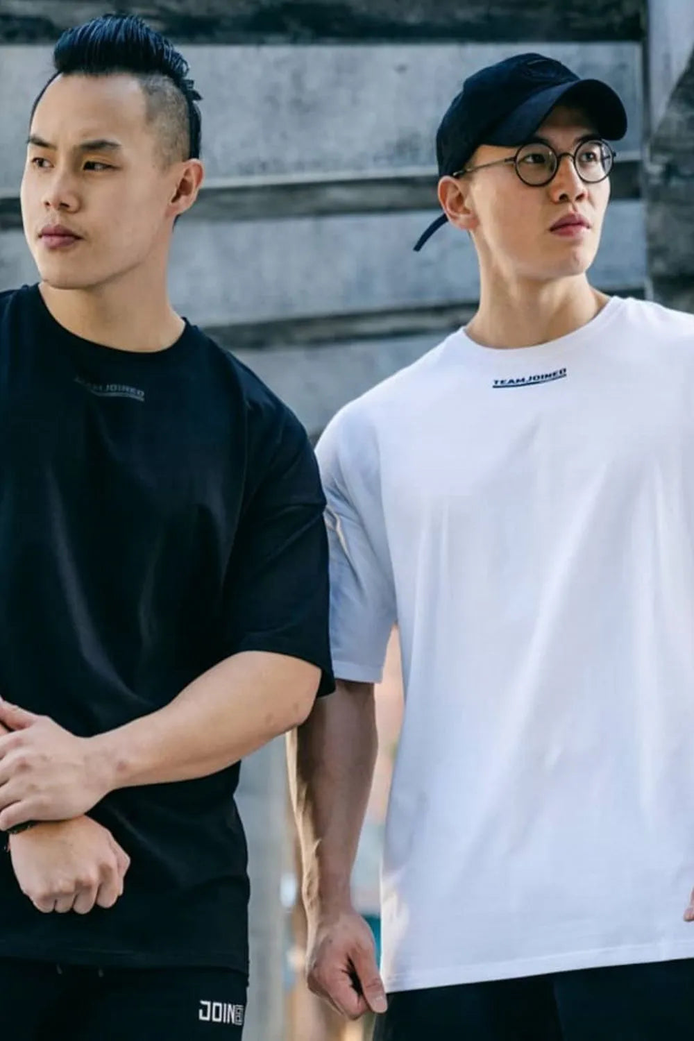 Oversized t-shirts in white and black with subtle chest logos, crew neck, short sleeves.