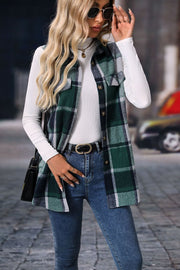 Plaid utility vest in dark green with patch pockets and button closure, worn over a white turtleneck.