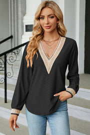 Black textured V-neck blouse with lace trim on neckline and cuffs