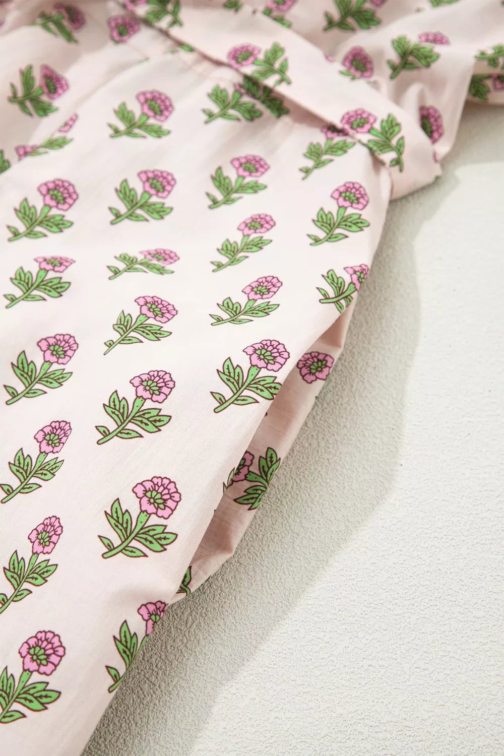 Blush pink floral midi dress with a V-neck and pocket detail.