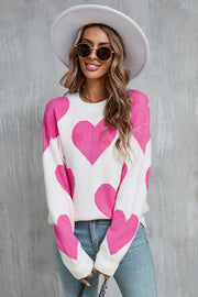 White knit sweater with large pink hearts, crew neck, long sleeves.