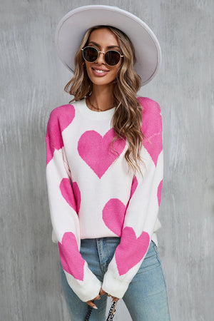 White knit sweater with large pink hearts, crew neck, long sleeves.