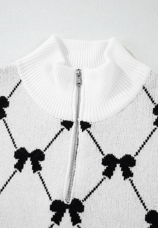 White knit zip vest with black diamond bow pattern and mock neck.