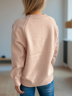 Apricot knit sweater with embroidered floral detail on raglan sleeves and crew neck.