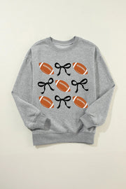 Gray sweatshirt with a grid pattern of footballs and black bows.