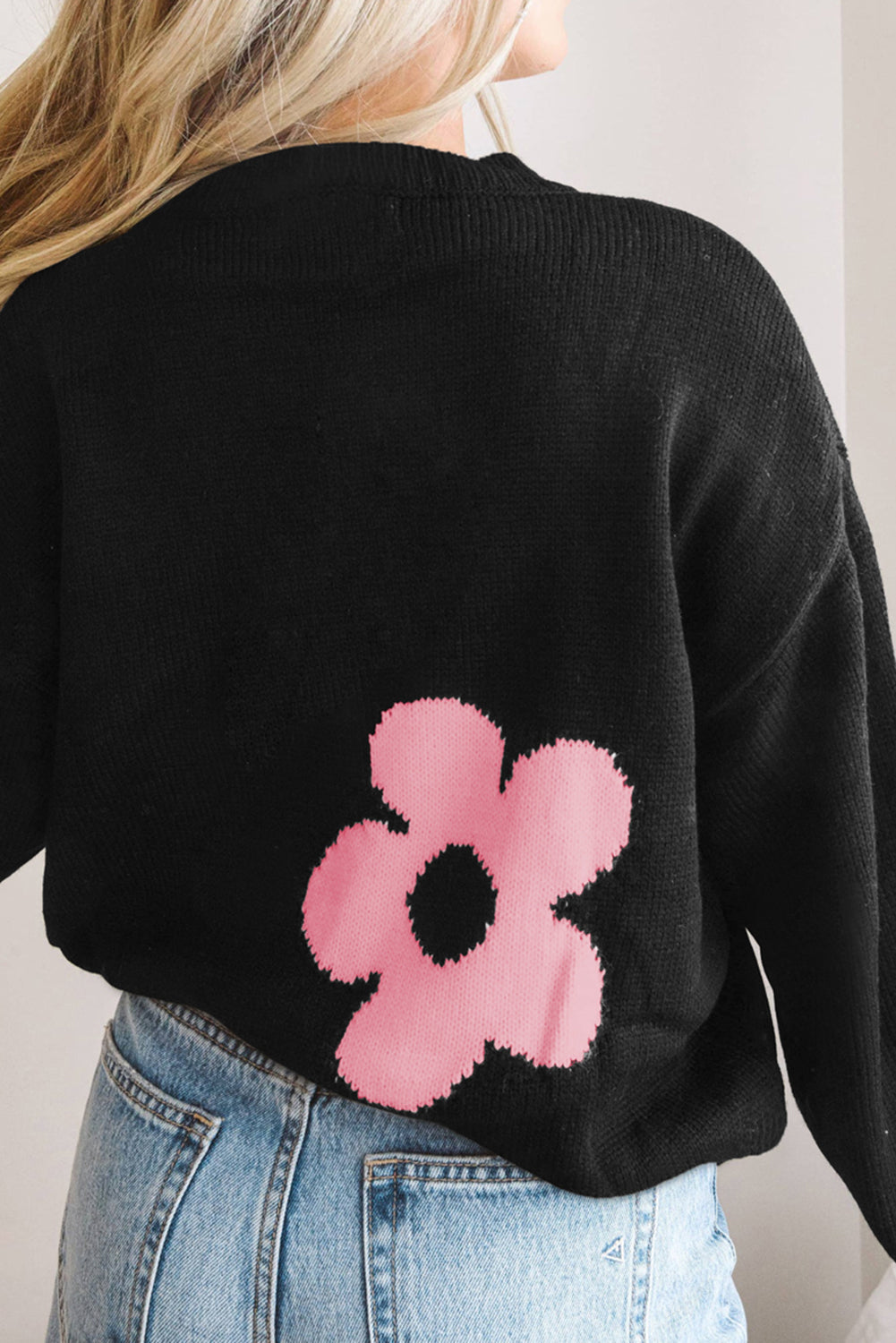 Black acrylic crewneck sweater with a pink floral intarsia knit detail.