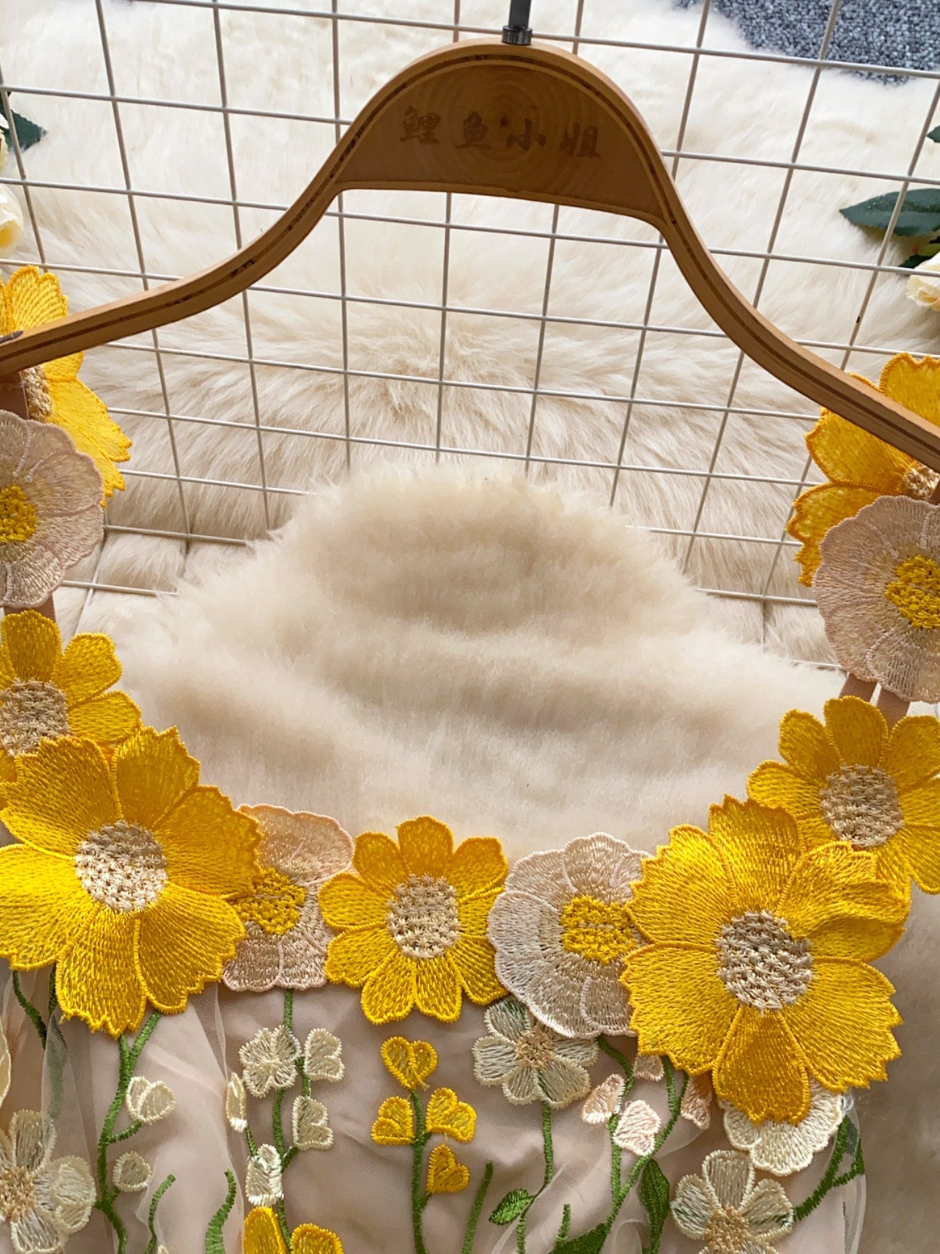 Embroidered floral mini dress with yellow and white flowers on sheer fabric.