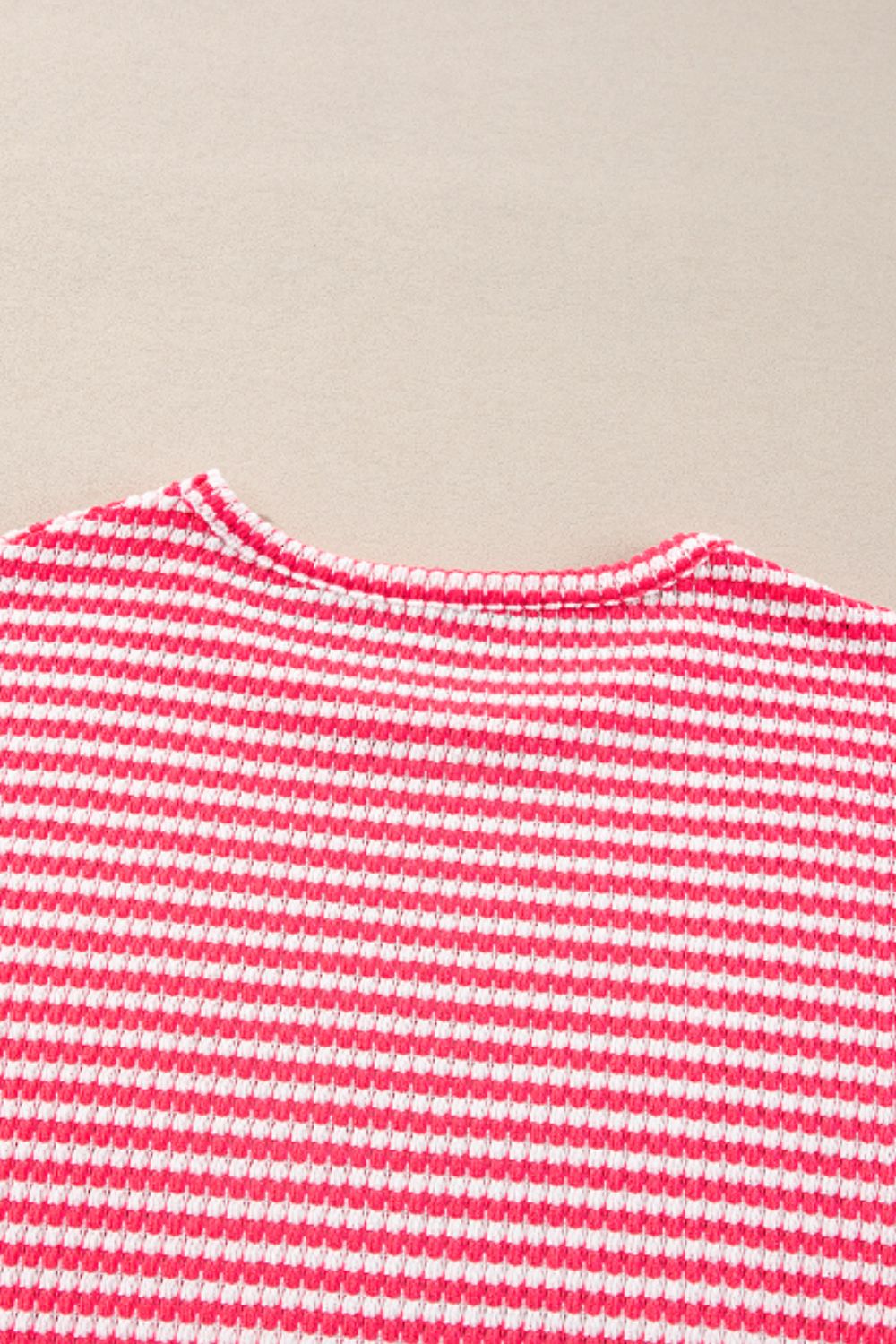 Pink and white striped textured top with crew neck and balloon sleeves.