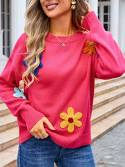 Pink knit sweater with embroidered flower appliqués and crew neck.