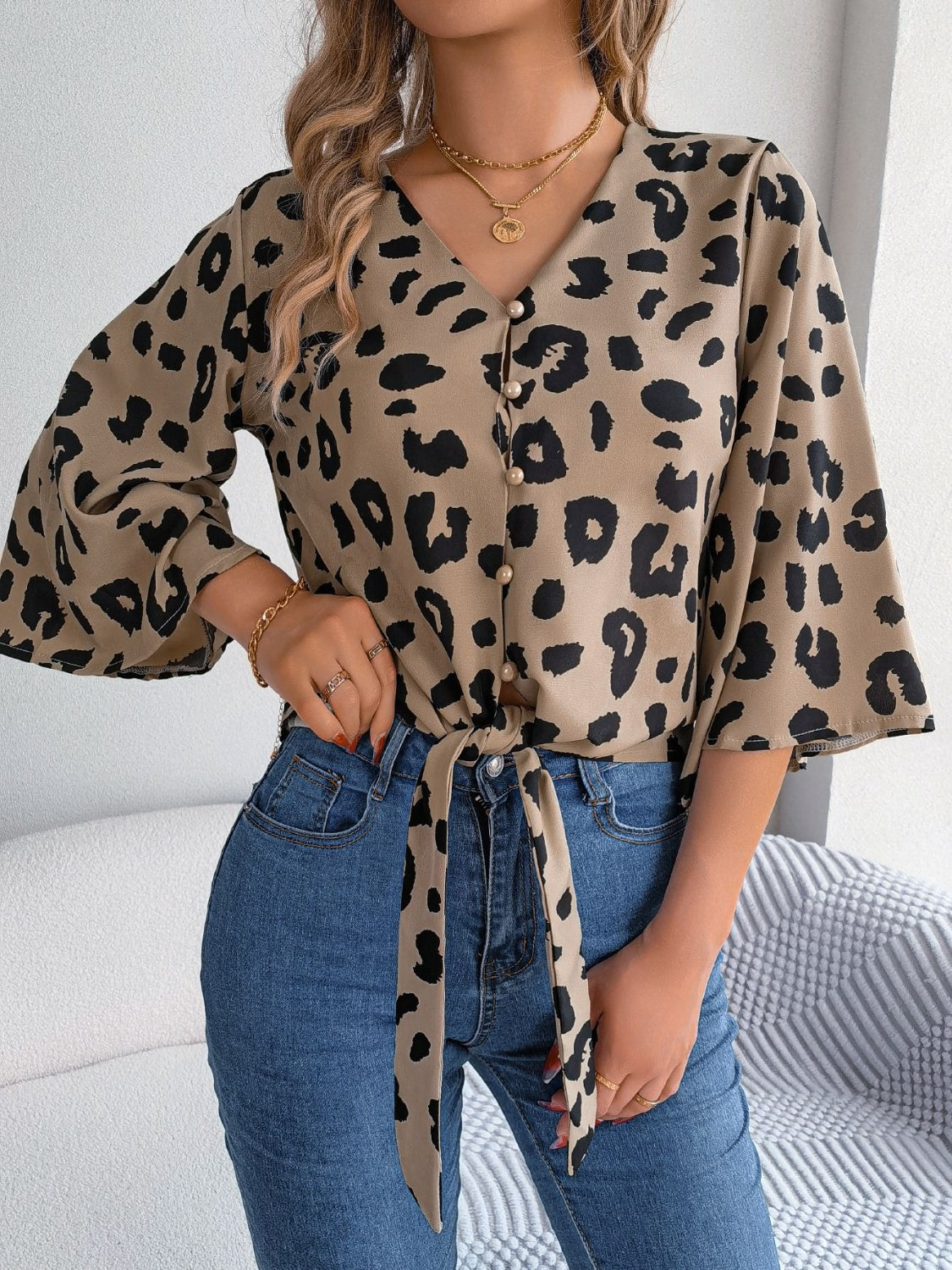 Khaki leopard print tie-front blouse with button detail and bell sleeves.