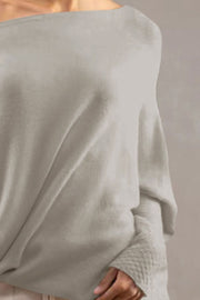 Light Gray off-shoulder knit sweater with textured cuffs and draped neckline.