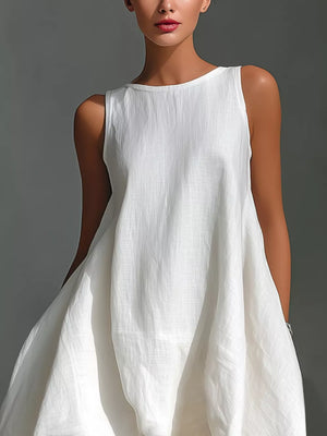 White asymmetrical sleeveless flowing dress with a relaxed fit and round neckline.