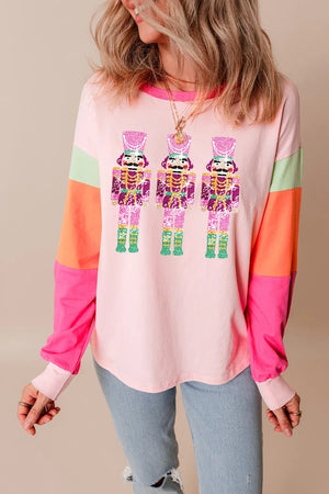 Blush pink long sleeve tee with colorblock sleeves and a sequin nutcracker graphic.