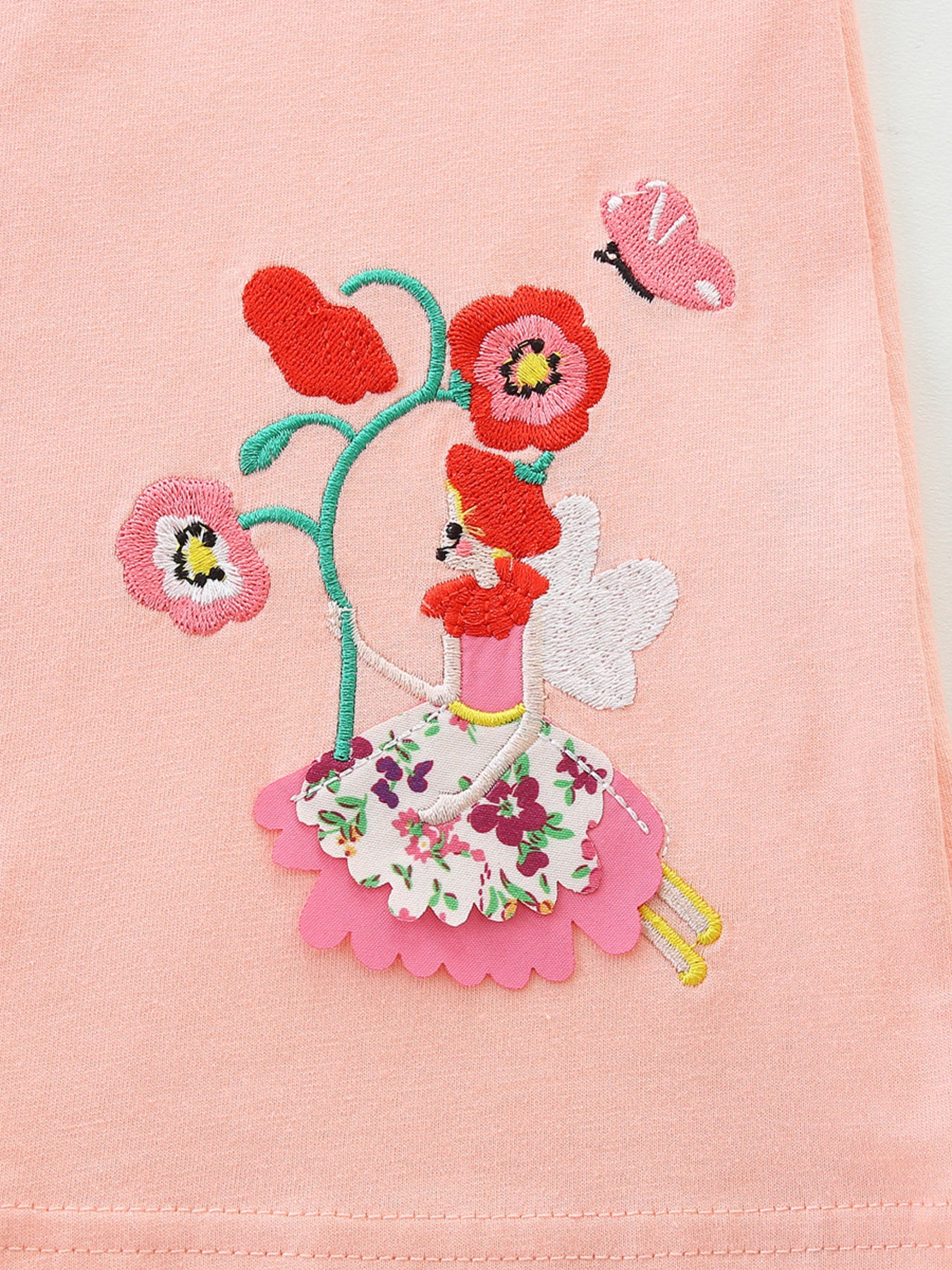 Toddler dress with whimsical fairy and floral embroidery on pink cotton.