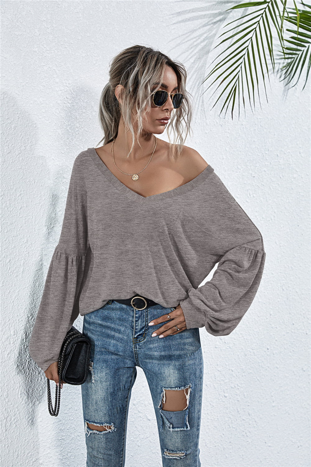 Off-shoulder knit top in dark gray with blouson sleeves and a V-neck.