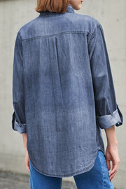 Relaxed light blue denim shirt with buttoned cuffs and a back pleat detail.