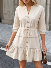 Apricot cotton V-neck button-down mini dress with ruffle hem and tie waist.