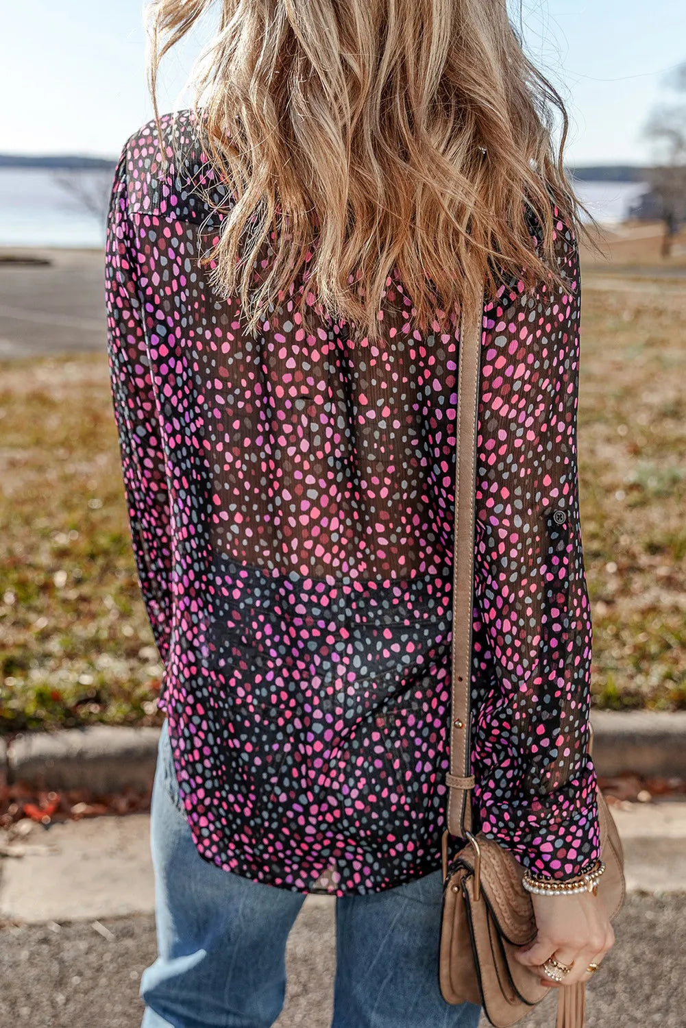 Black dotted sheer blouse with knot detail and long sleeves.
