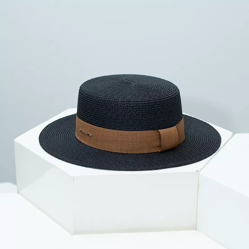 Black woven straw boater hat with brown ribbon band and gold accent