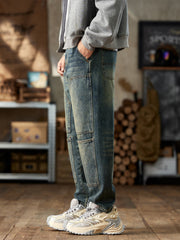Men's blue cotton straight leg jeans with textured knee panels.