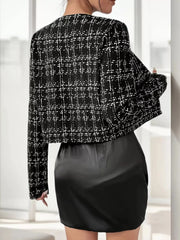 Black tweed cropped jacket with white plaid pattern and long sleeves.