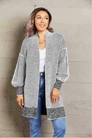 Textured puff sleeve open cardigan in black and white knit with a relaxed fit and ribbed cuffs.