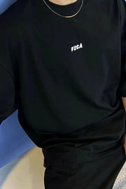 Black oversized tee with drop shoulder and small white chest logo