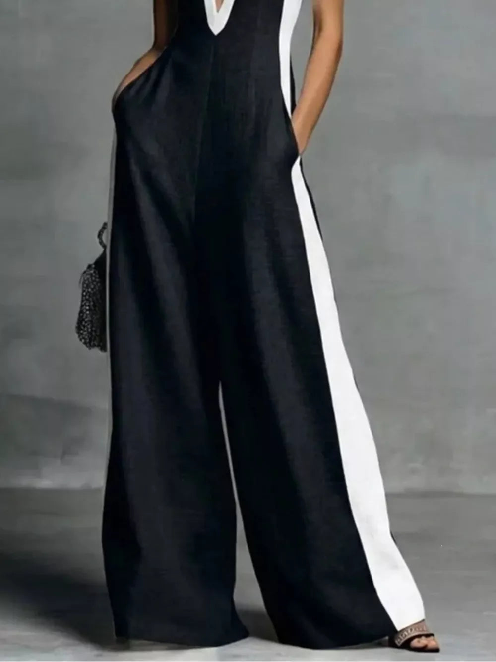 Black wide-leg jumpsuit with contrast trim, deep V-neck, and pockets.