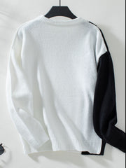 Colorblock knit sweater in white with black raglan sleeves and crewneck.