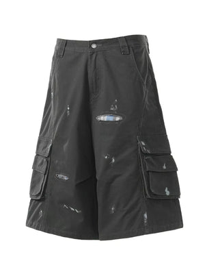 Black distressed maternity cargo capris with multiple pocket details and a plaid patch.