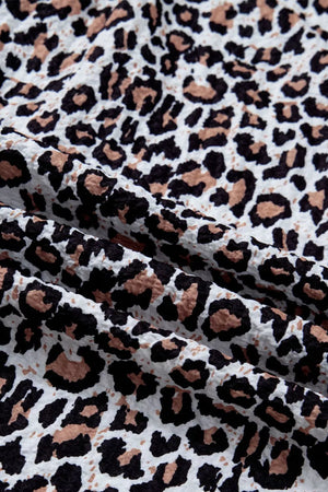 Leopard print V-neck frilled polyester shirt with a textured fabric detail.