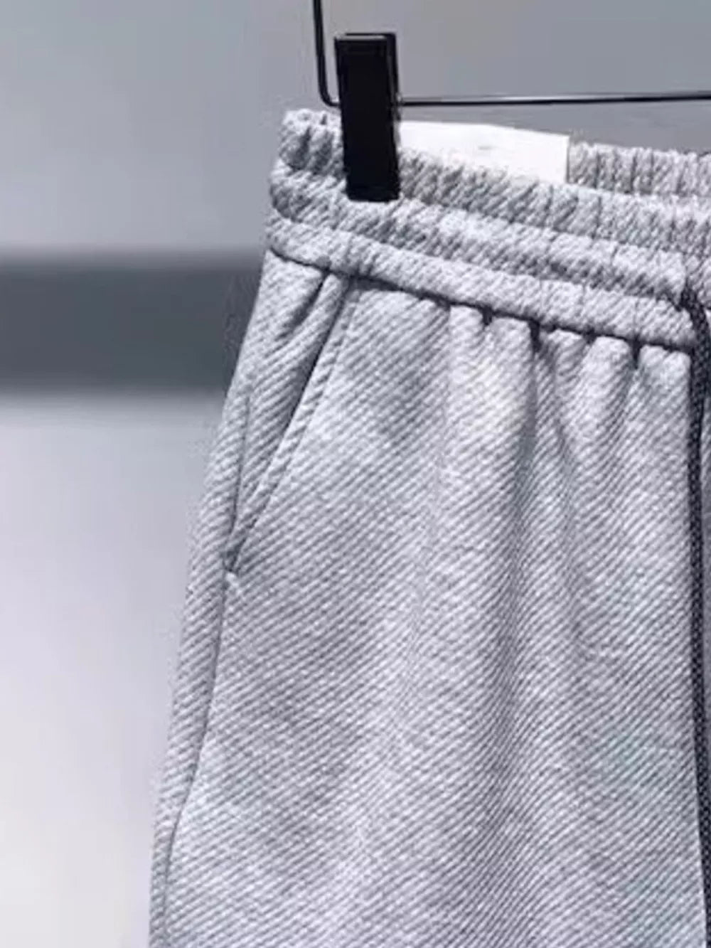 Gray drawstring boxer shorts with pockets and elastic waistband.