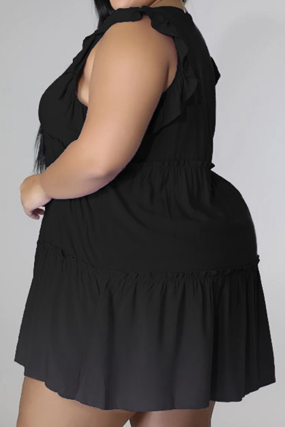 Black tiered ruffle babydoll mini dress with smocked waist and ruffled hem.