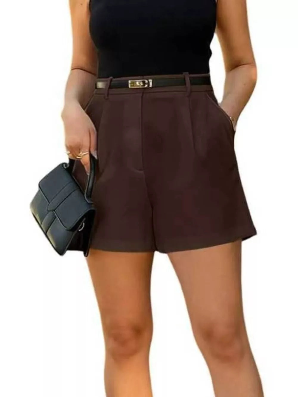 High-waisted pleated shorts in dark brown with a black belt and pockets.