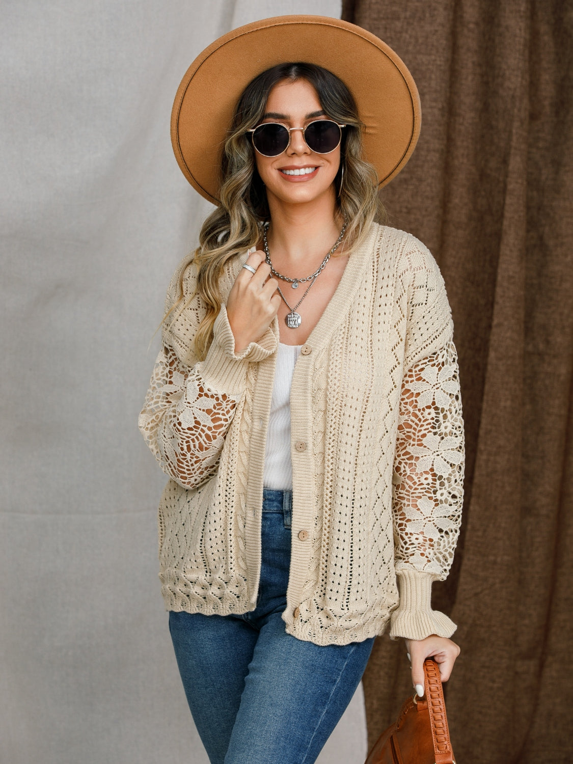 Tan lace sleeve knit cardigan with button front and cable knit details.