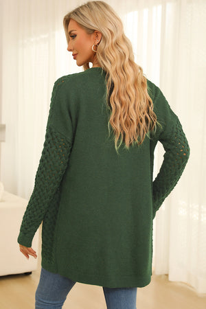 Dark green open-knit pocket cardigan with textured sleeves.